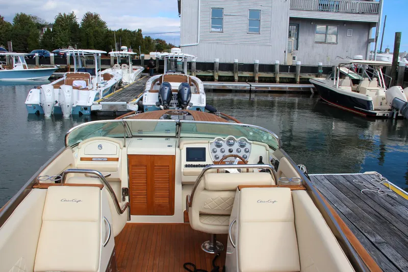 Slide: The Image of 2017 Chris-Craft Corsair 32 docked at marina, showcasing elegant interior and dashboard. - 22