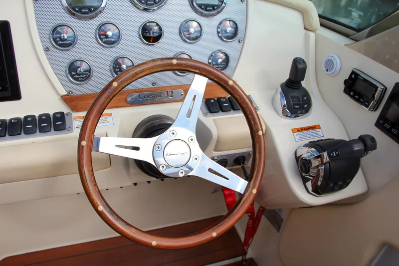 Slide: The Image of Chris-Craft Corsair 32 dashboard with wooden steering wheel, gauges, and controls, 2017 model. - 31
