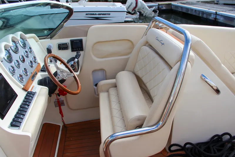 Slide: The Image of Luxurious 2017 Chris-Craft Corsair 32 cockpit with leather seating and wooden steering wheel. - 34