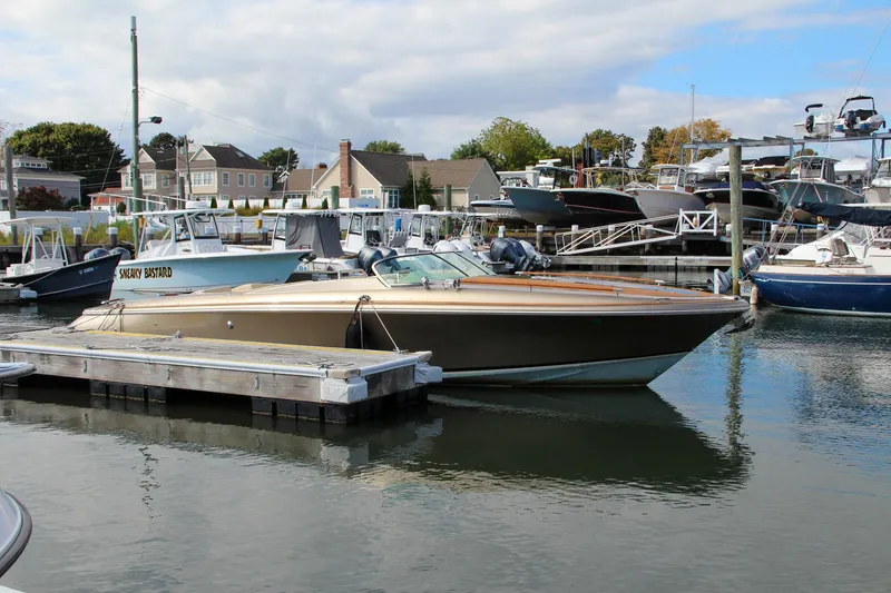 Slide: The Image of 2017 Chris-Craft Corsair 32 docked in a marina, surrounded by other boats. - 39