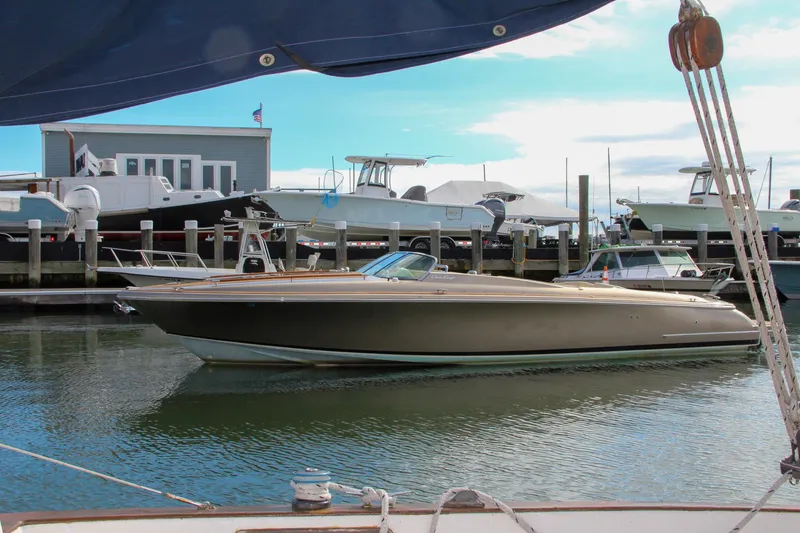 Slide: The Image of 2017 Chris-Craft Corsair 32 boat docked in a marina, surrounded by other vessels. - 41