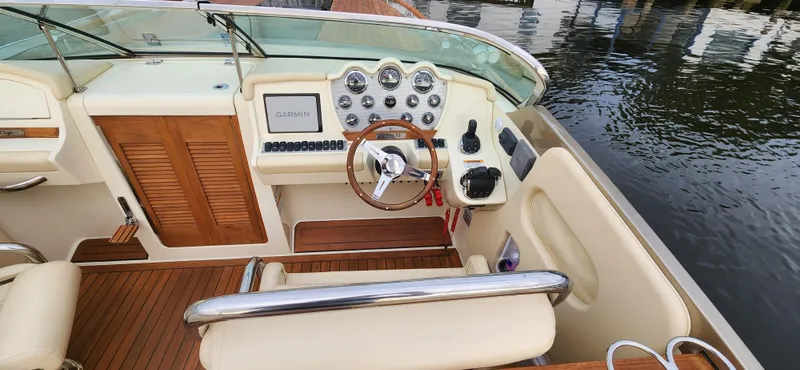 Slide: The Image of 2017 Chris-Craft Corsair 32 boat interior with wooden dashboard and steering wheel. - 9
