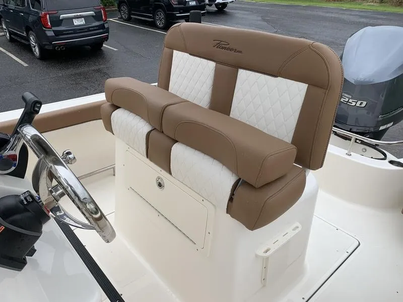 Slide: The Image of 2025 Pioneer SPORTFISH 222 boat seating with tan and white upholstery. - 13