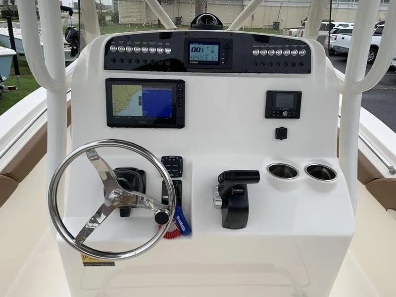 Slide: The Image of 2025 Pioneer SPORTFISH 222 boat dashboard with steering wheel and navigation controls. - 17