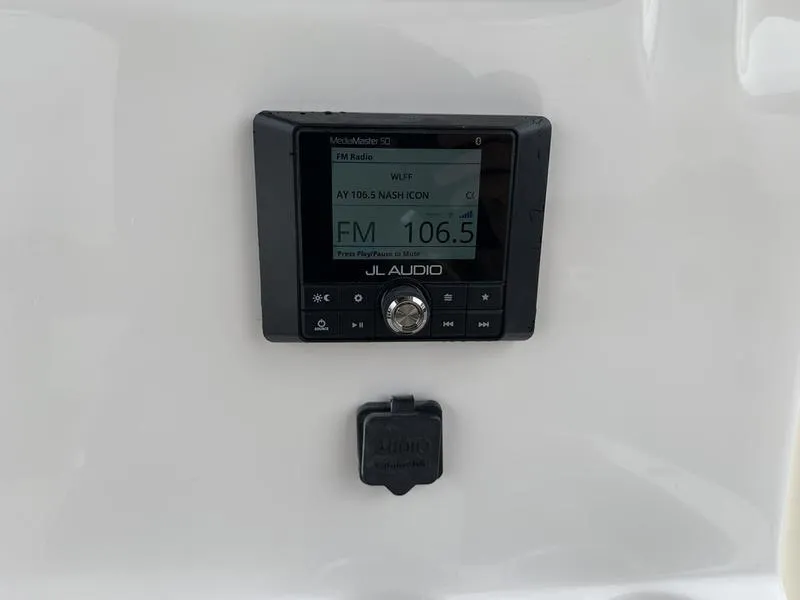 Slide: The Image of JL Audio system on 2025 Pioneer SPORTFISH 222 boat dashboard, displaying FM 106.5. - 20