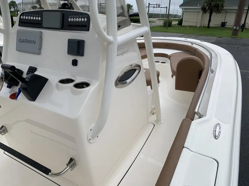 Slide: The Image of 2025 Pioneer SPORTFISH 222 boat interior with Garmin navigation system and seating area. - 21