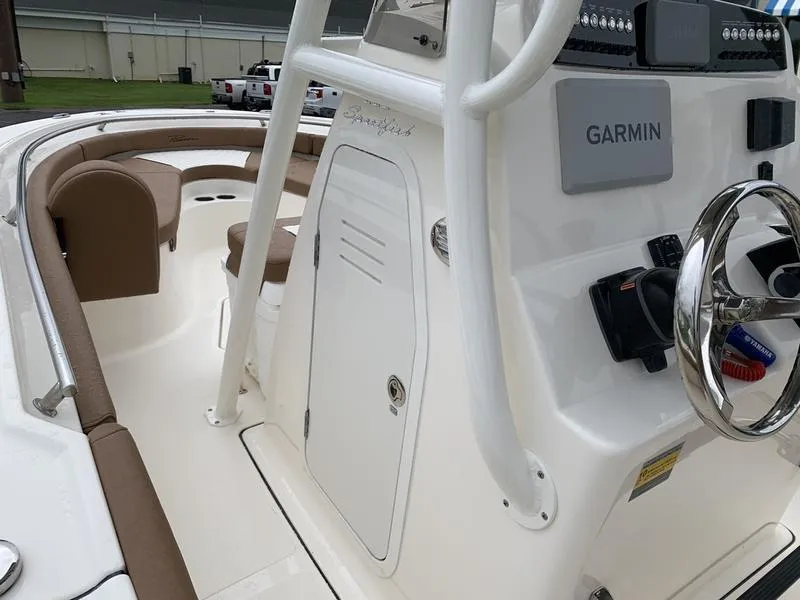 Slide: The Image of 2025 Pioneer SPORTFISH 222 boat interior with Garmin navigation system and seating area. - 22