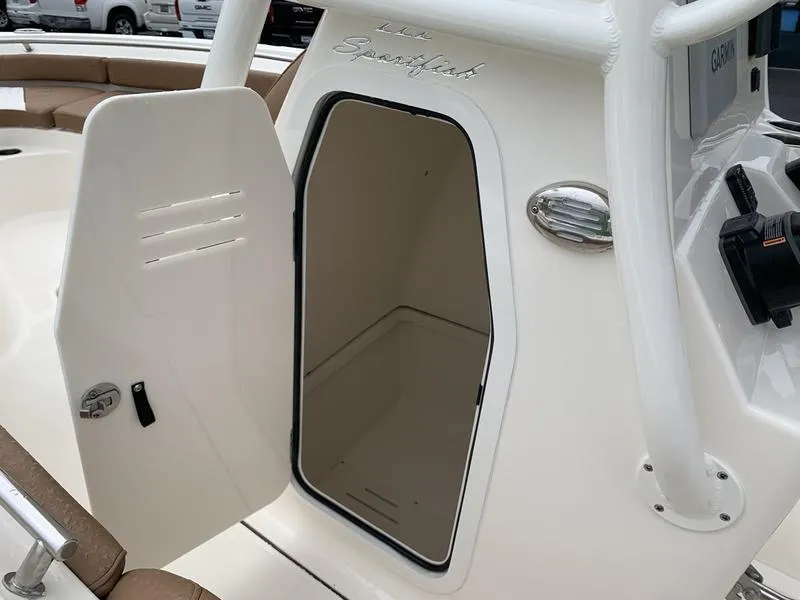 Slide: The Image of 2025 Pioneer SPORTFISH 222 boat with open storage compartment door. - 23
