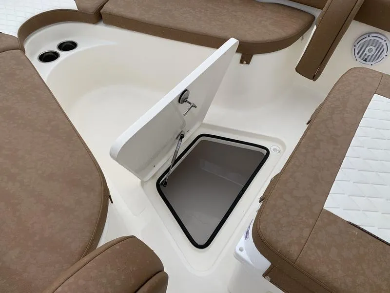 Slide: The Image of 2025 Pioneer SPORTFISH 222 boat interior with open storage compartment and cushioned seating. - 26