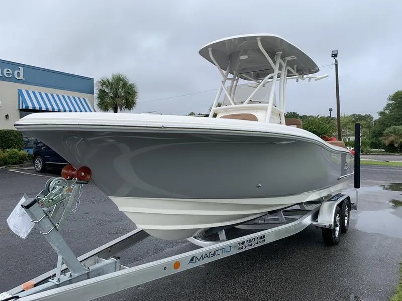 Slide: The Image of 2025 Pioneer SPORTFISH 222 boat on trailer, parked outdoors on a cloudy day. - 7