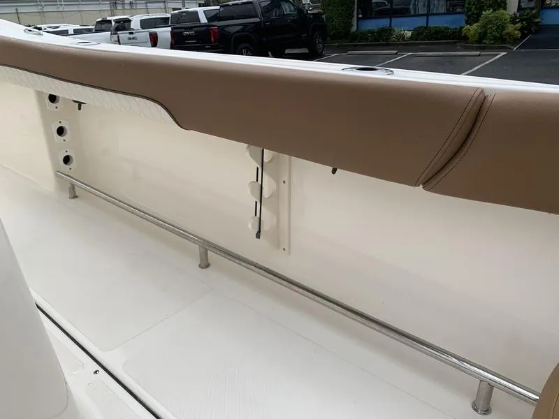 Slide: The Image of 2025 Pioneer SPORTFISH 222 boat interior with beige seating and rod holders. - 9