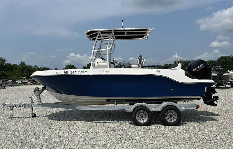 The Image of 2022 Bayliner Trophy T20CX boat on trailer, blue and white design, parked outdoors. - 0