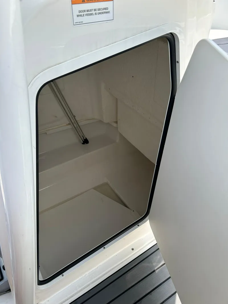 Slide: The Image of 2022 Bayliner Trophy T20CX storage compartment with open door. - 11