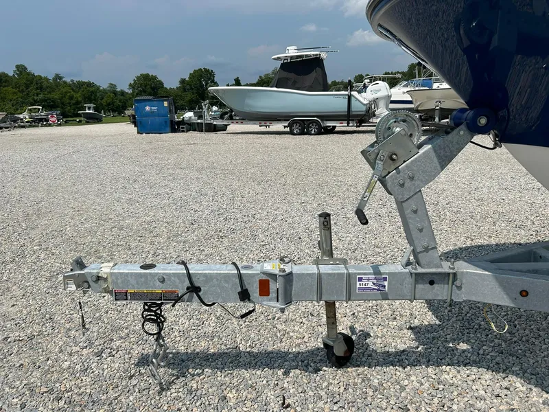 Slide: The Image of 2022 Bayliner Trophy T20CX boat trailer on gravel lot with other boats. - 25