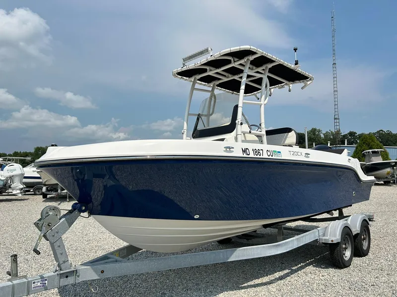 Slide: The Image of 2022 Bayliner Trophy T20CX boat on trailer, blue hull, sunny day. - 26
