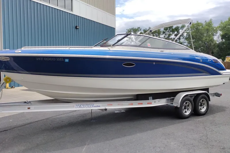 Slide: The Image of 2016 Formula 270 Bowrider boat on trailer, blue and white exterior, parked outdoors. - 10