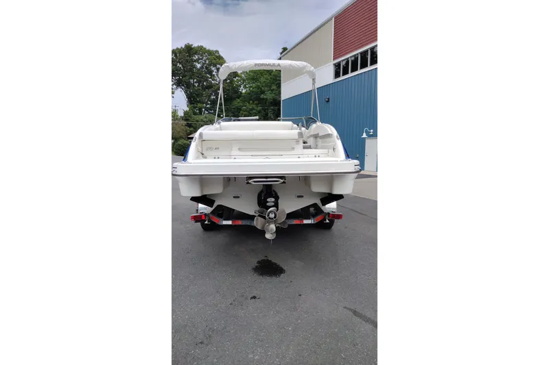 Slide: The Image of 2016 Formula 270 Bowrider boat, rear view, parked outdoors near a blue building. - 5