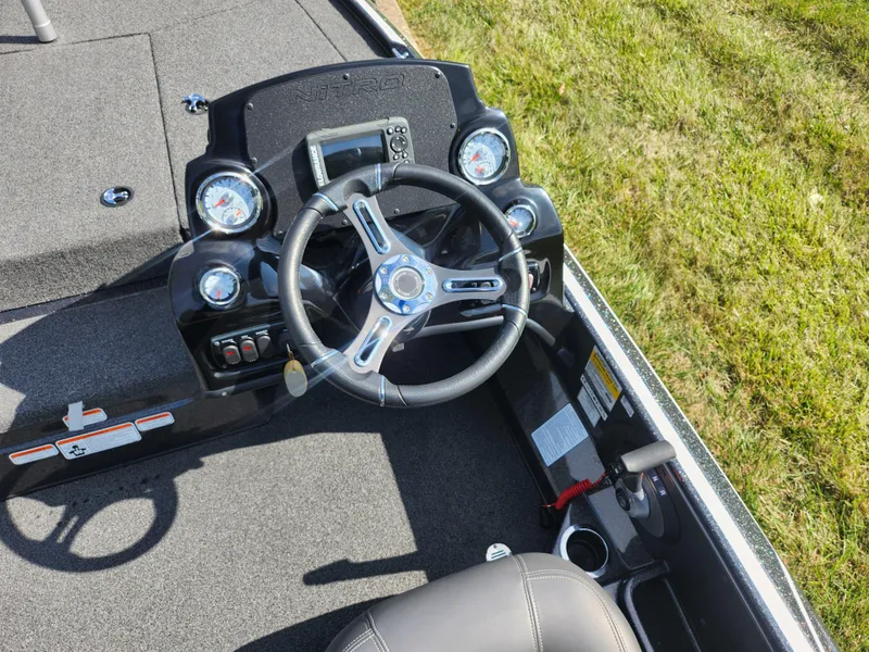 Slide: The Image of 2021 Nitro Z17 boat dashboard with steering wheel and gauges, parked on grass. - 12