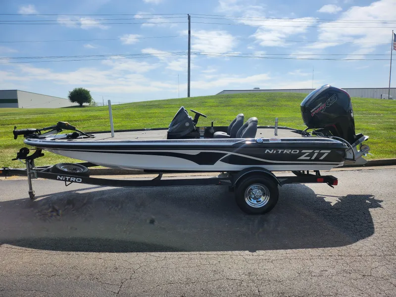 Slide: The Image of 2021 Nitro Z17 fishing boat on trailer, parked outdoors under a clear sky. - 4