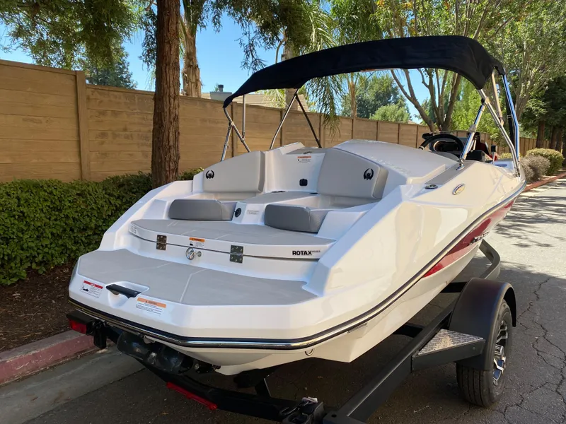 Slide: The Image of 2025 Scarab 165 SE boat on trailer, parked on a tree-lined street. - 5