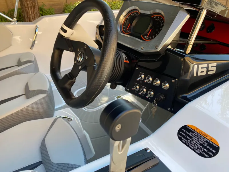 Slide: The Image of Interior of 2025 Scarab 165 SE boat with steering wheel and dashboard controls. - 8