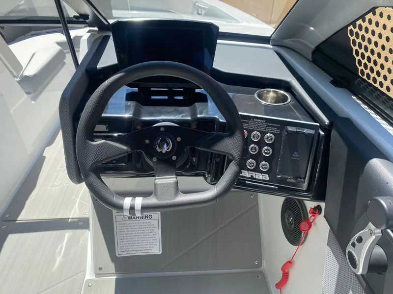 Slide: The Image of 2025 Scarab 235 SE boat dashboard with steering wheel and control panel. - 14