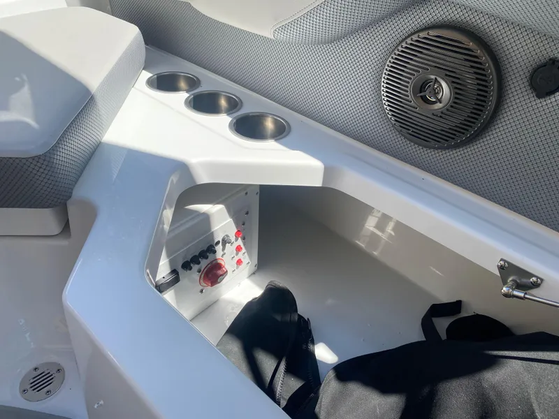 Slide: The Image of 2025 Scarab 235 SE boat interior with cup holders and storage compartment. - 21