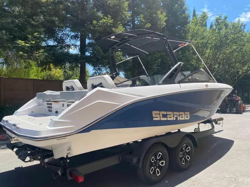 Slide: The Image of 2025 Scarab 235 SE boat on trailer, parked outdoors. - 25