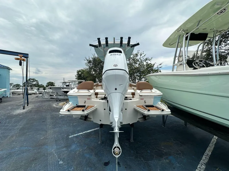 Slide: The Image of 2025 Pioneer 202 Islander boat with outboard motor in a marina setting. - 3