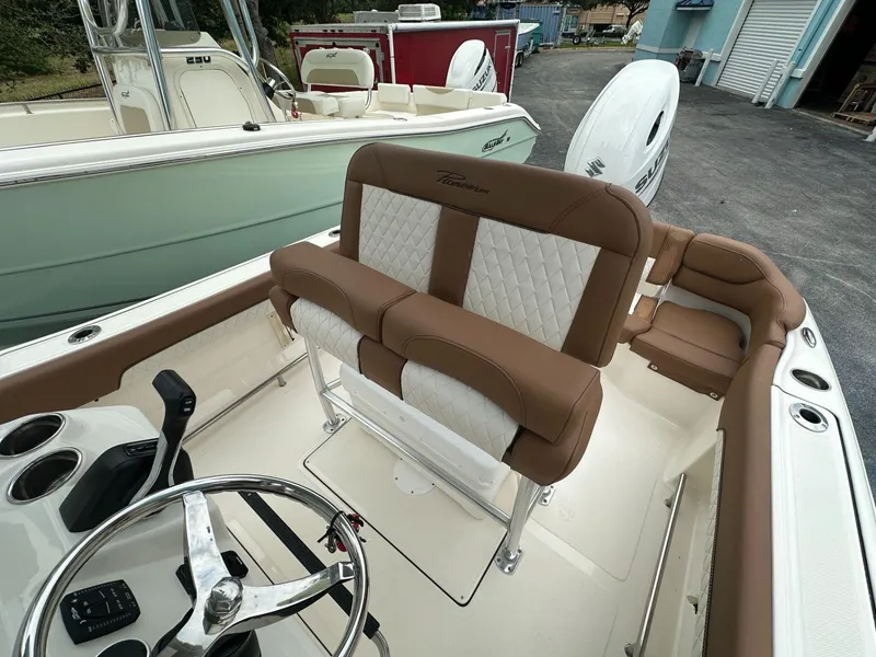 Slide: The Image of 2025 Pioneer 202 Islander boat interior with brown and white seating, steering wheel, and controls. - 8
