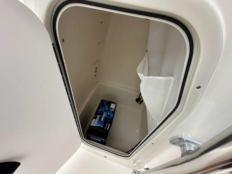 Slide: The Image of Storage compartment in 2025 Bulls Bay 230 CC boat, featuring a box and mesh pocket. - 9