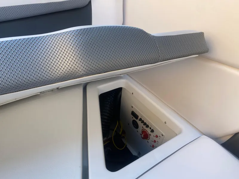 Slide: The Image of 2025 Scarab 255 ID boat interior with storage compartment and control panel. - 25