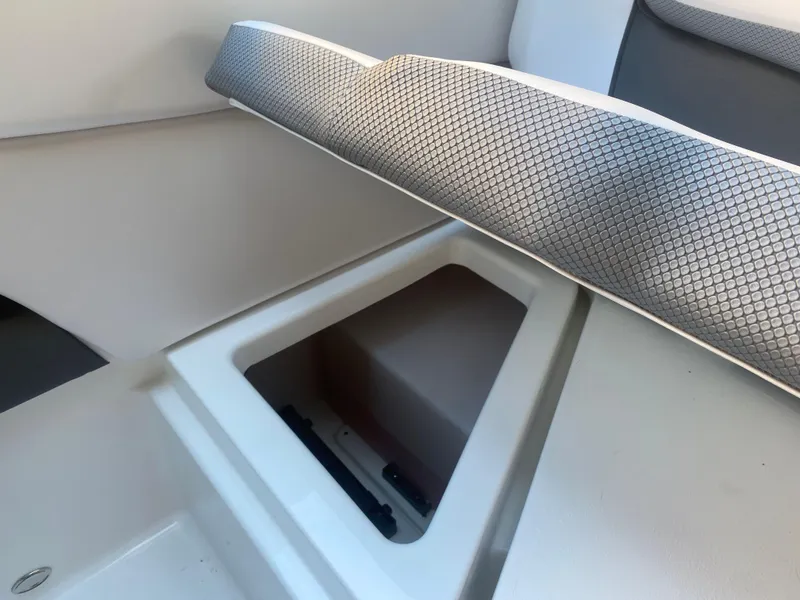 Slide: The Image of 2025 Scarab 255 ID boat interior storage compartment with cushioned seating. - 26