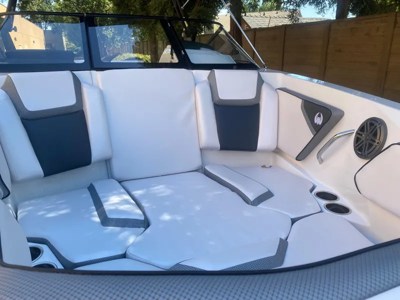 Slide: The Image of 2025 Scarab 255 ID boat interior with white and gray seating, cup holders, and speaker. - 7