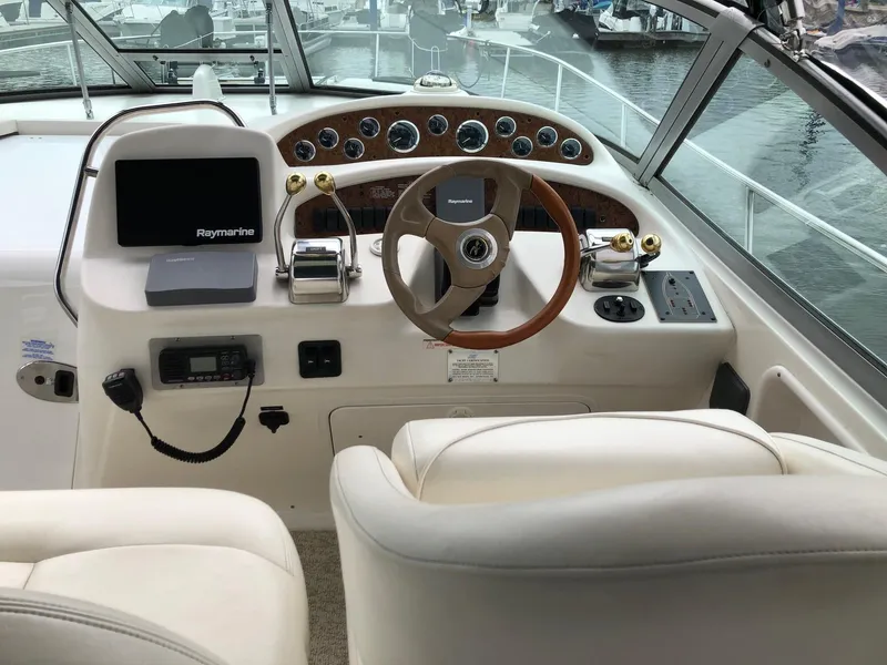 Slide: The Image of 2001 Sea Ray 340 Sundancer helm with Raymarine electronics and luxurious seating. - 12