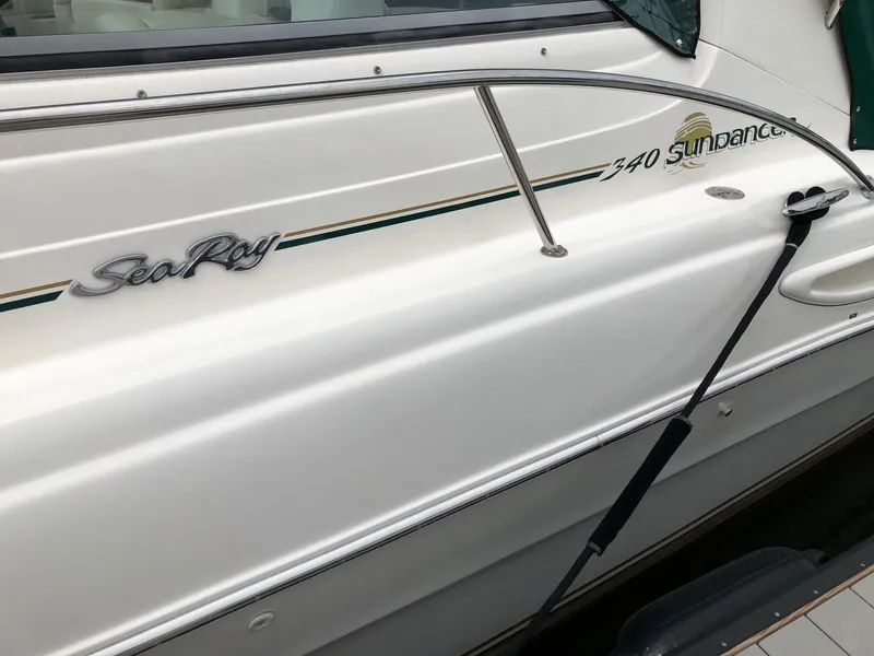 Slide: The Image of 2001 Sea Ray 340 Sundancer boat side view with logo and railing. - 3