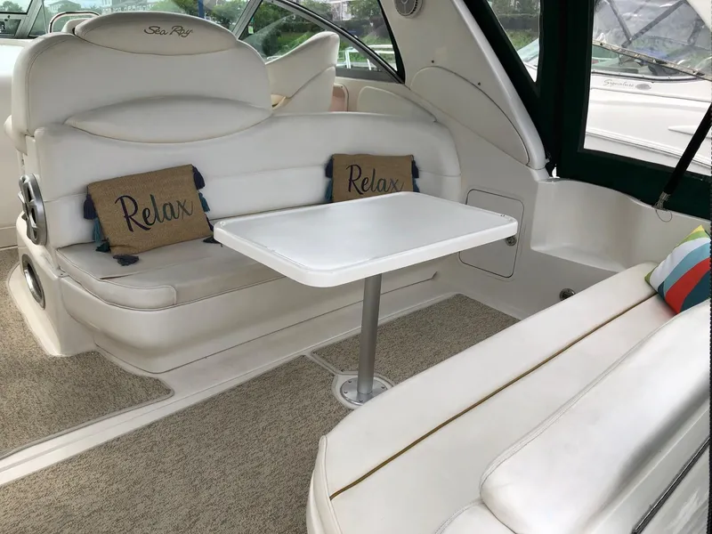 Slide: The Image of 2001 Sea Ray 340 Sundancer interior with white seating and "Relax" pillows. - 7