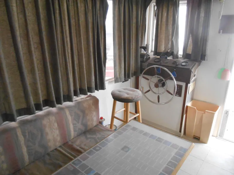 Slide: The Image of 1972 Boatel Hurcules interior with steering wheel, stool, and sofa. - 10