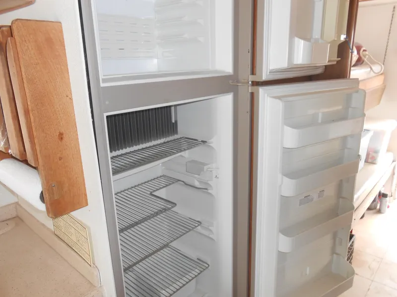 Slide: The Image of Open refrigerator inside a 1972 Boatel Hurcules, showing empty shelves and door compartments. - 13