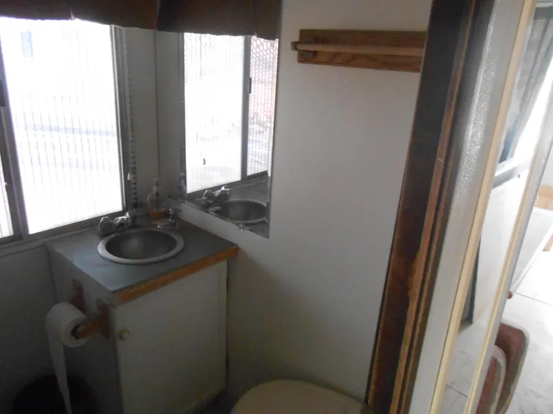 Slide: The Image of 1972 Boatel Hurcules bathroom interior with sink, toilet, and window. - 14