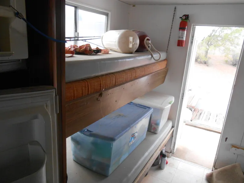Slide: The Image of Interior of 1972 Boatel Hurcules with bunk beds and storage containers. - 16