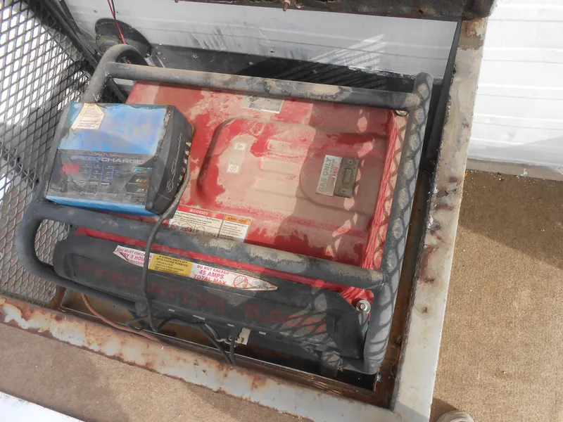 Slide: The Image of Battery compartment of a 1972 Boatel Hurcules, featuring a red battery and charger. - 6