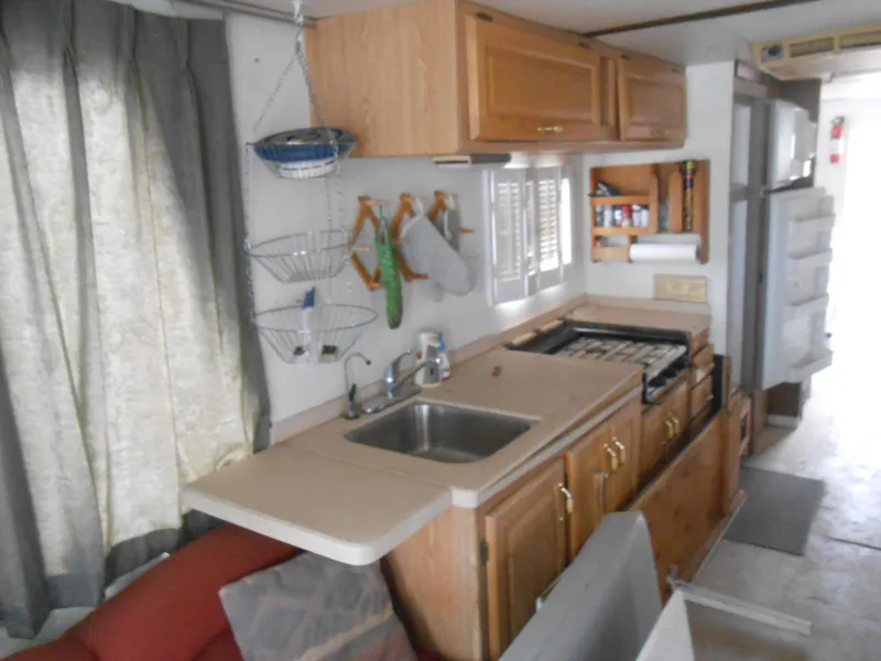 Slide: The Image of 1972 Boatel Hurcules kitchen interior with wooden cabinets and compact appliances. - 9