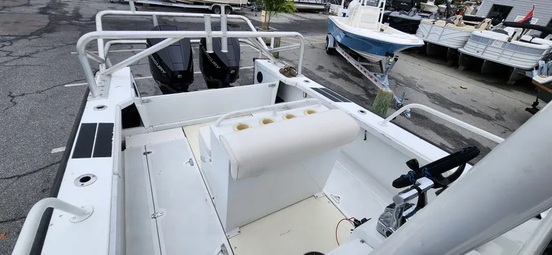 Slide: The Image of 2000 Boston Whaler Justice 24 boat interior with seating and dual engines. - 13