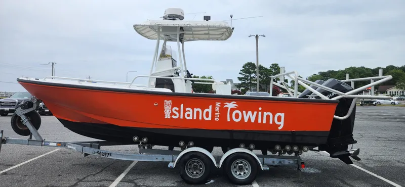 Slide: The Image of Boston Whaler Justice 24 boat, 2000 model, with "Island Towing" branding, on a trailer. - 3