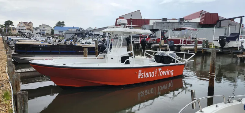 Slide: The Image of 2000 Boston Whaler Justice 24 boat docked at marina, labeled "Island Towing." - 4