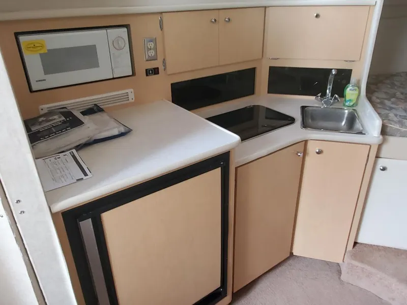 Slide: The Image of 2000 Bayliner 3055 Ciera Sunbridge DX/LX boat kitchen with microwave, sink, and stove. - 11