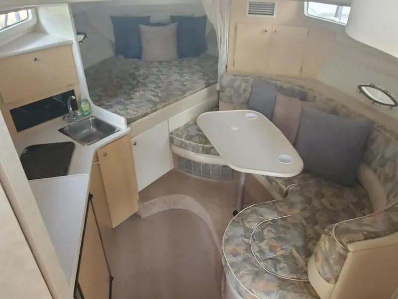 Slide: The Image of Interior of 2000 Bayliner 3055 Ciera Sunbridge DX/LX with cozy seating and compact kitchen. - 7