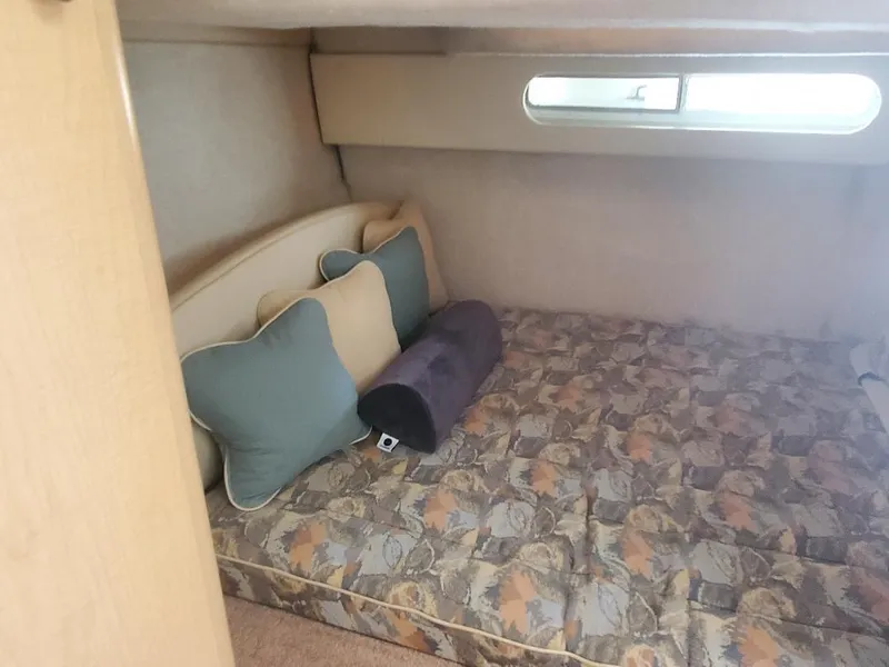 Slide: The Image of 2000 Bayliner 3055 Ciera Sunbridge cabin interior with bed and cushions. - 8