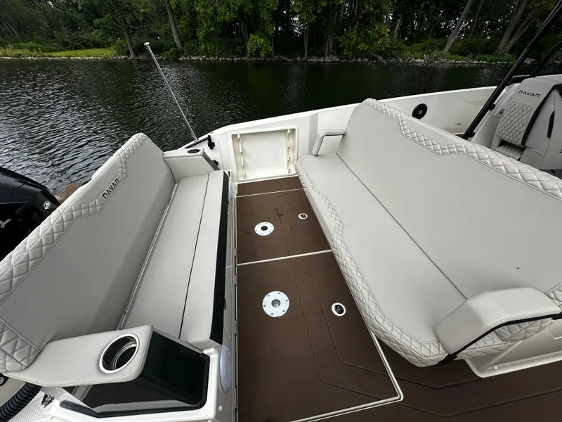 Slide: The Image of 2024 Navan S30 boat interior with cushioned seating and cup holders by a lake. - 21